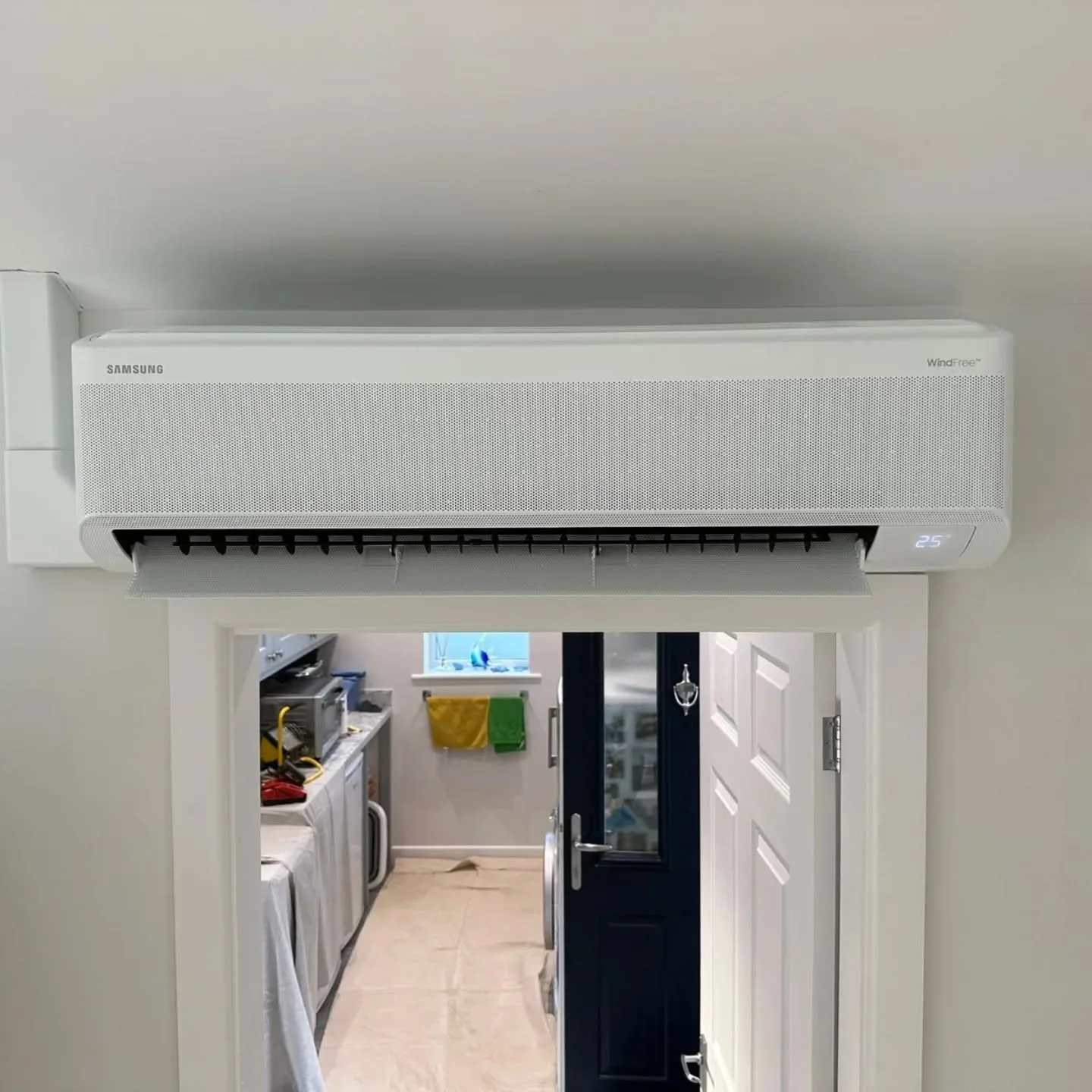 Samsung WindFree wall-mounted split unit installed above a utility-room doorway
