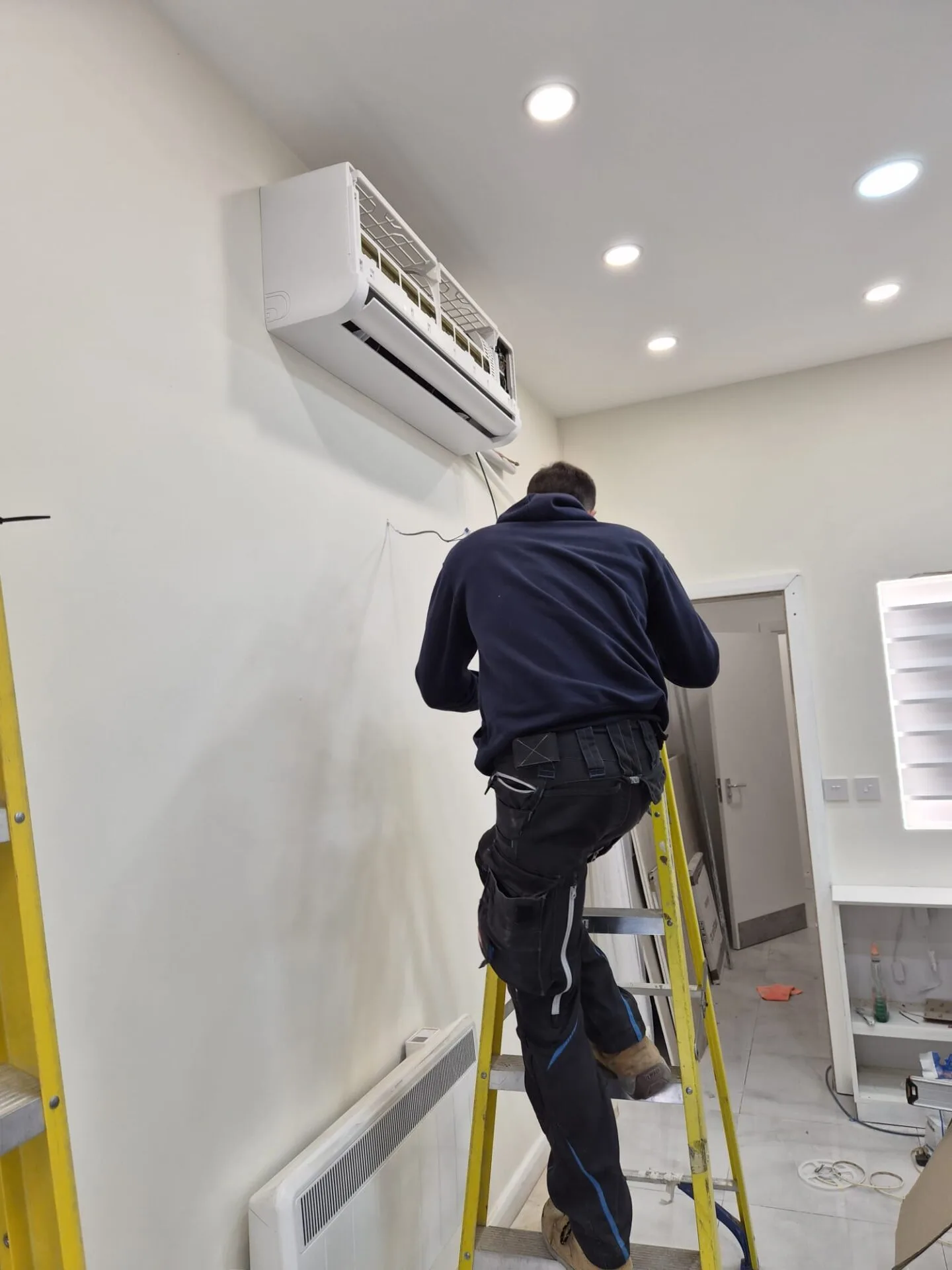 Engineer commissioning a wall-mounted split air conditioning unit